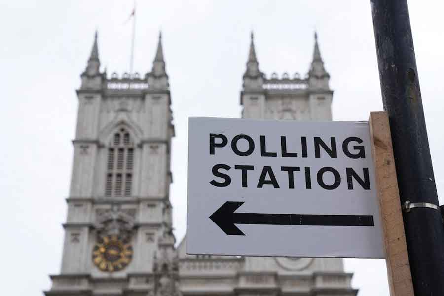 A polling station direction sign is attached to a street sign near to Westminster Abbey, ahead of general elections, in London, Britain July 3, 2024.