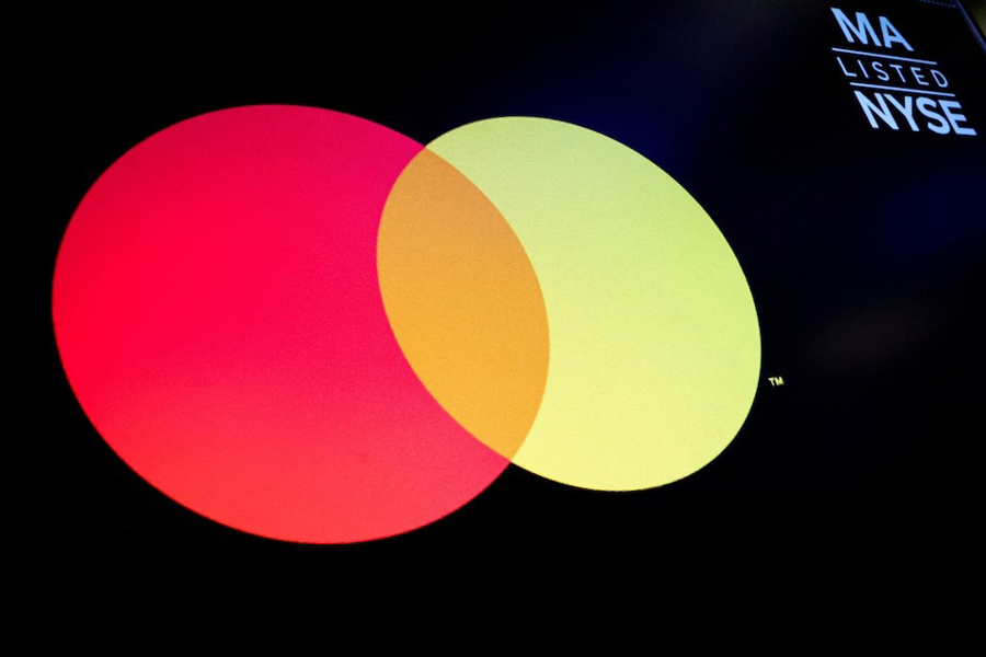 A screen displays the company logo for Mastercard Inc. on the floor at the New York Stock Exchange (NYSE) in New York City, US, February 29, 2024.