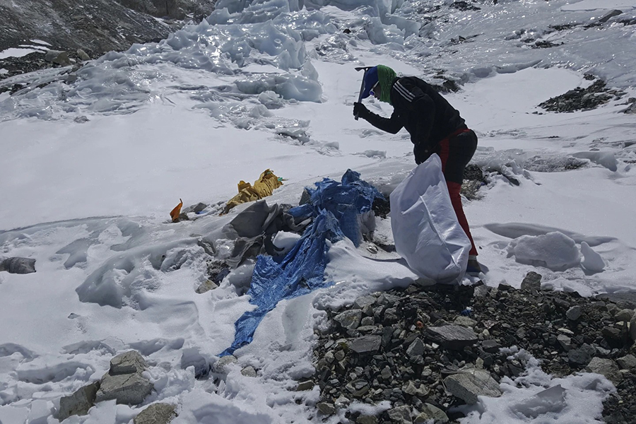 This image provided by the Peak Promotion shows a member of the Nepal government-funded team using a spade to remove frozen trash en route the Mount Everest, Nepal on Tuesday, April 27, 2021 — (Peak Promotion via AP)