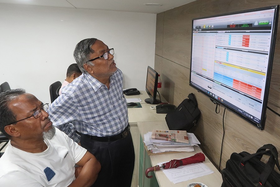 Investors react while monitoring stock price movements on TV and computer screens at a brokerage house in the capital city — FE/File