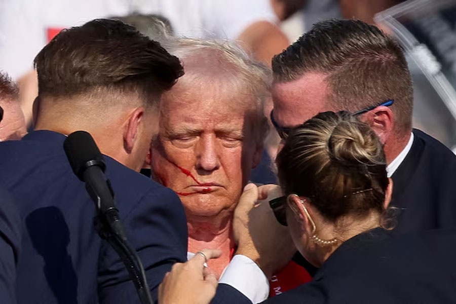 Republican presidential candidate and former U.S. President Donald Trump is assisted by the Secret Service after gunfire rang out during a campaign rally at the Butler Farm Show in Butler, Pennsylvania, U.S., July 13, 2024.