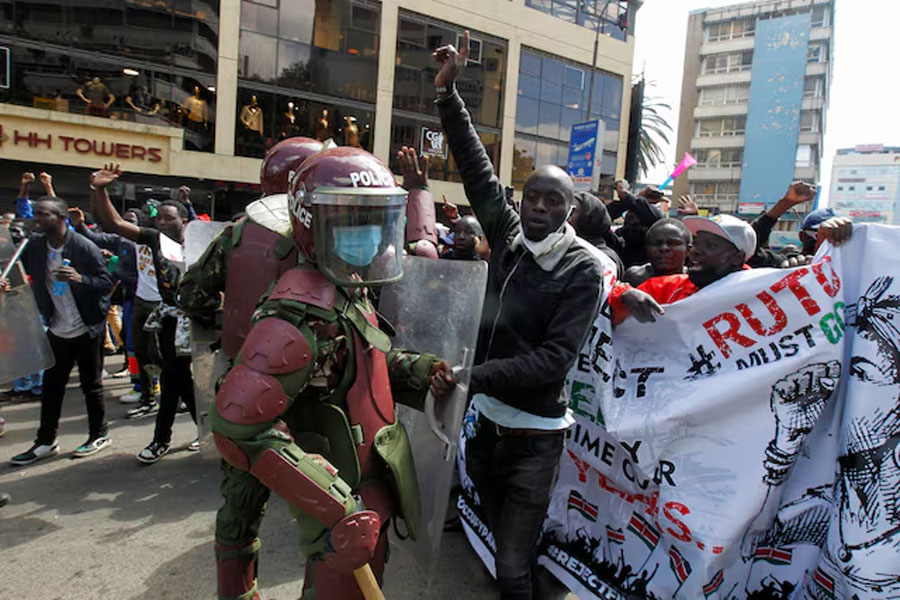 Demonstrators react as police stand guard during a demonstration against Kenya's proposed finance bill 2024/2025 in Nairobi, Kenya, June 25, 2024.