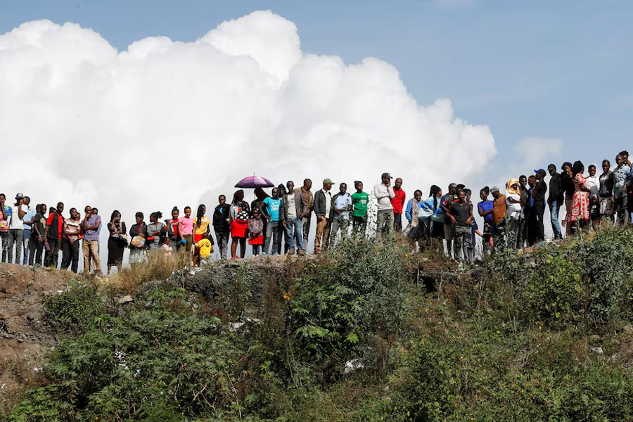 People watch as volunteers retrieve bodies of an unknown people from a dumpsite in Mukuru slums, in Nairobi, Kenya, July 12, 2024.