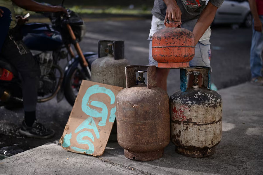 A man stacks gas canisters in a street stall, as Venezuela prepares for presidential elections, in Caracas, Venezuela July 20, 2024.