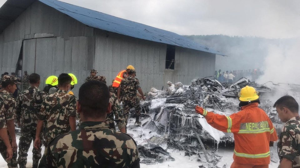 Emergency services work at the accident site of a Saurya Airlines plane that caught fire after skidding off the runway while taking off, in Kathmandu, Nepal on July 24, 2024 — NepaliArmyHQ via X/Handout via REUTERS