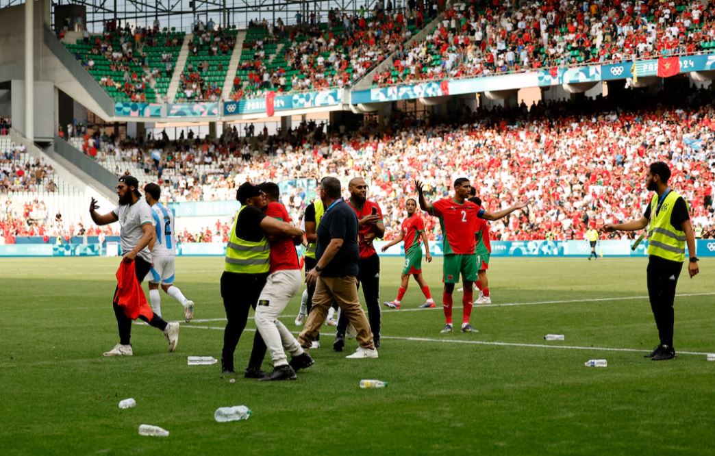 Paris 2024 Olympics - Football - Men's Group B - Argentina vs Morocco - Geoffroy-Guichard Stadium, Saint-Etienne, France - July 24, 2024. Achraf Hakimi of Morocco reacts as pitch invaders run to the pitch after the match. REUTERS/Thaier Al-Sudani