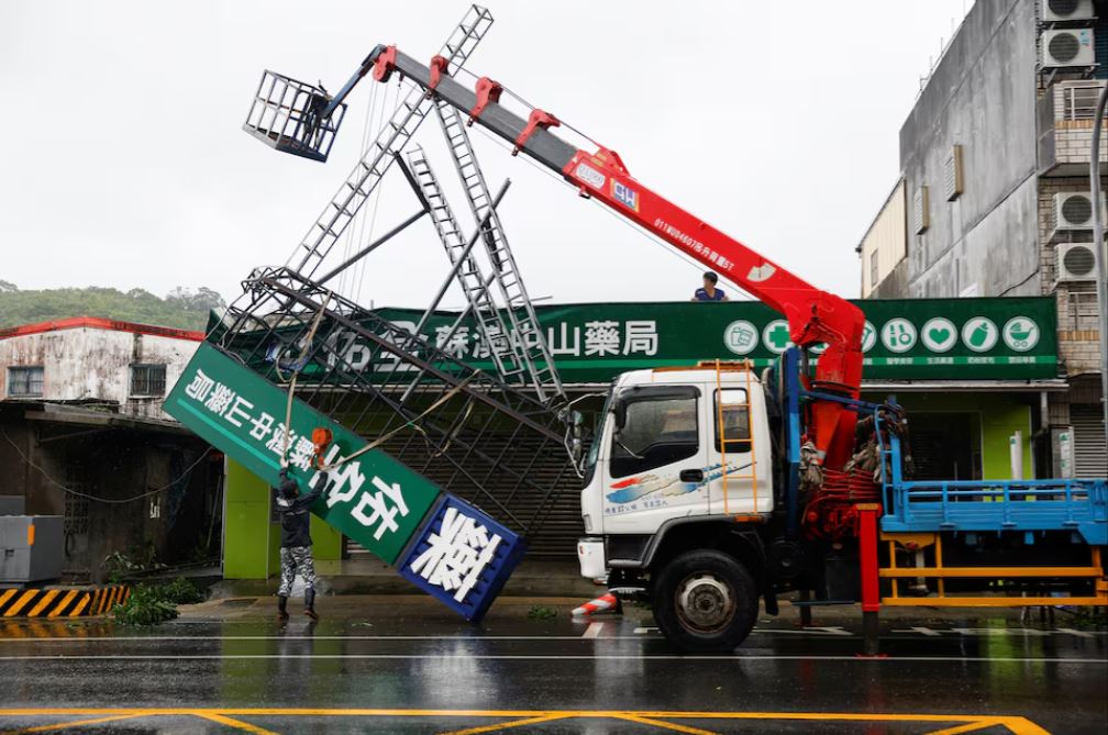 Workers use a crane to remove a fallen sign after Typhoon Gaemi passed northern Taiwan in Yilan, Taiwan July 25, 2024. REUTERS/Carlos Garcia Rawlins