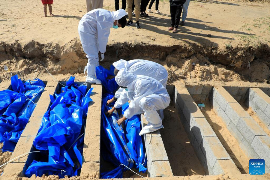 Palestinian workers bury a body at a grave for victims killed in the Hamas-Israel conflict in the southern Gaza Strip city of Rafah on Janurary 30, 2024 — Xinhua Photo