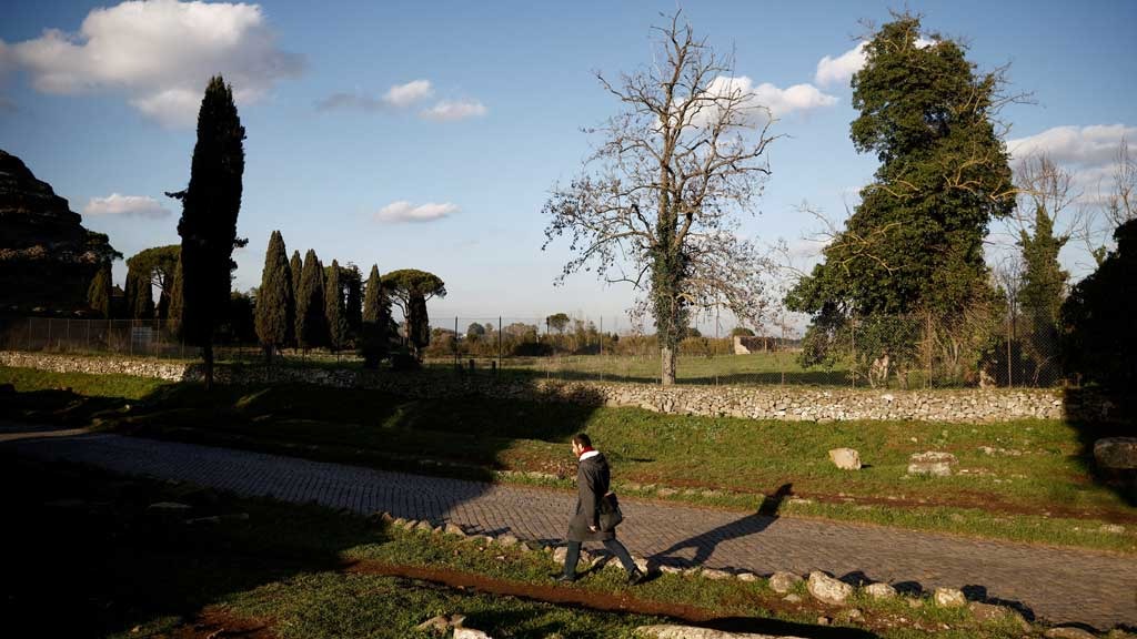 A man walks on the old Appian Way, ancient Rome's first highway, near the area where a life-sized statue of a Roman emperor posing as the classical hero Hercules was discovered during sewer repair works in Rome, Italy, February 1, 2023. REUTERS/Guglielmo Mangiapane