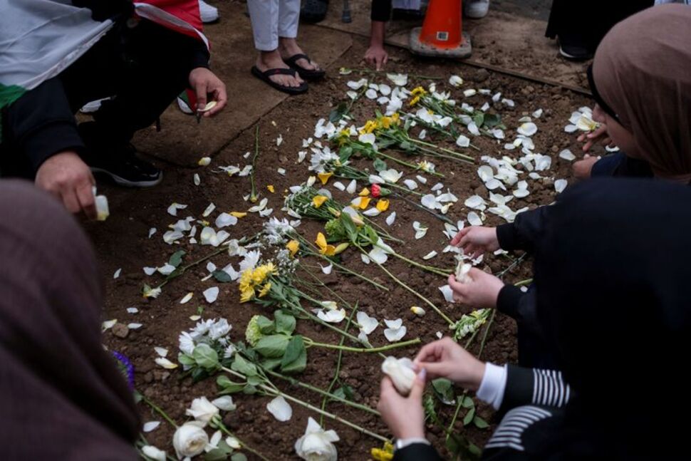 Mourners place flowers at the grave of Wadea Al-Fayoume at Parkholm Cemetery where the burial took place of Wadea Al-Fayoume, 6, a Muslim boy who according to police was stabbed to death in an attack that targeted him and his mother for their religion and as a response to the war between Israel and Hamas, in LaGrange, Illinois, U.S. October 16, 2023. REUTERS/Jim Vondruska/File Photo