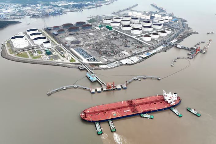 An aerial view shows tugboats helping a crude oil tanker to berth at an oil terminal, off Waidiao Island in Zhoushan, Zhejiang province, China July 18, 2022. cnsphoto via REUTERS/File Photo
