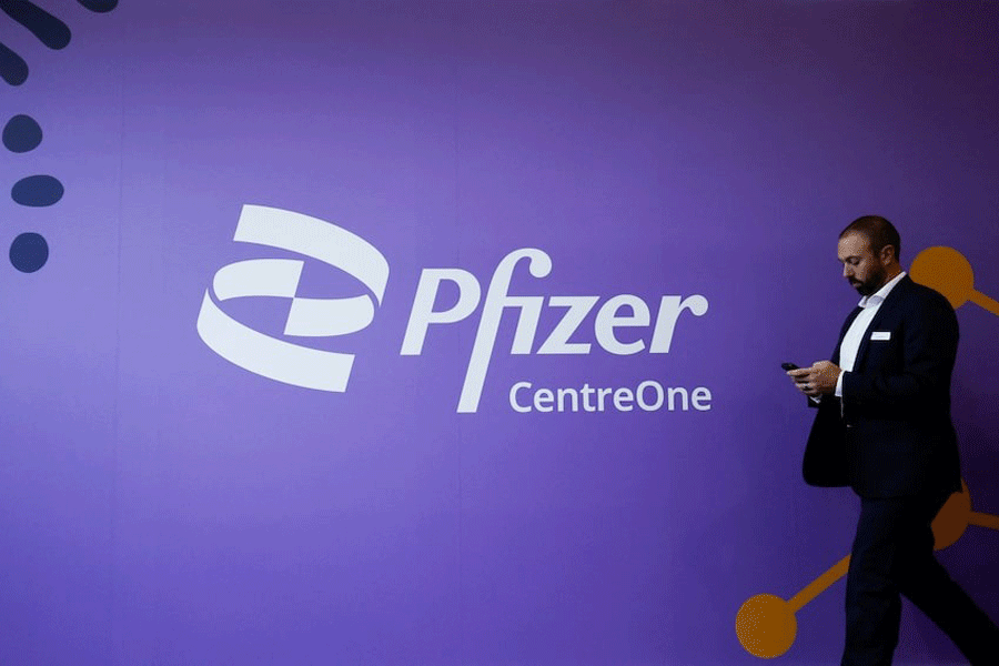 A man walks past a Pfizer logo during the Convention on Pharmaceutical Ingredients (CPHI), in Barcelona, Spain, October 24, 2023.