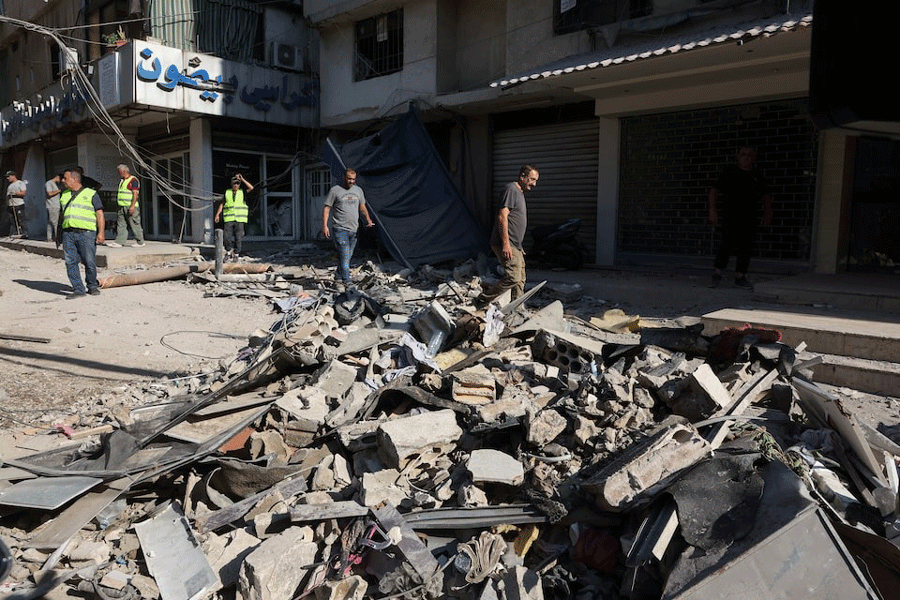 People walk on the rubble of a damaged site the day after an Israeli strike, in Beirut’s southern suburbs, Lebanon July 31, 2024.