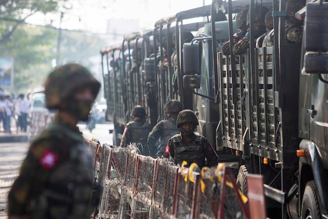 Soldiers stand next to military vehicles as people gather to protest against the military coup, in Yangon, Myanmar on February 15, 2021 — Reuters/File