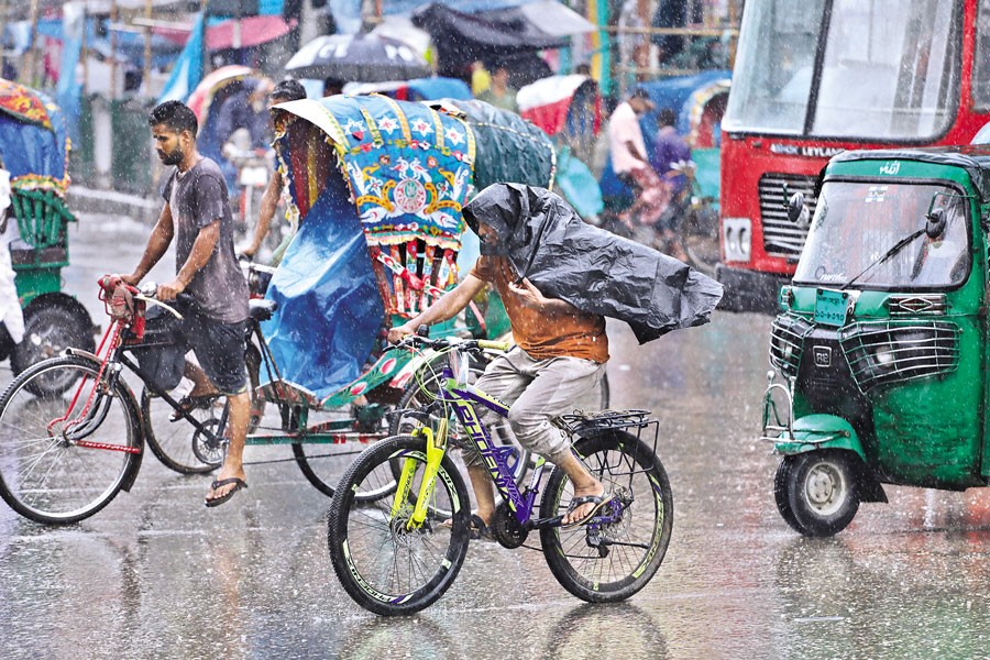 A cyclist covered himself partially with a plastic sheet while crossing the capital's Zero Point area, as spells of downpour caused inconvenience to the city dwellers on Thursday