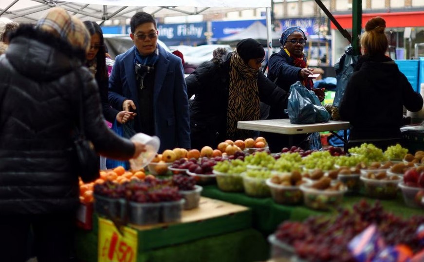 People shop to buy fruit and vegetables at a stall in Lewisham Market, south east London, Britain, March 9, 2023. REUTERS/Hannah McKay