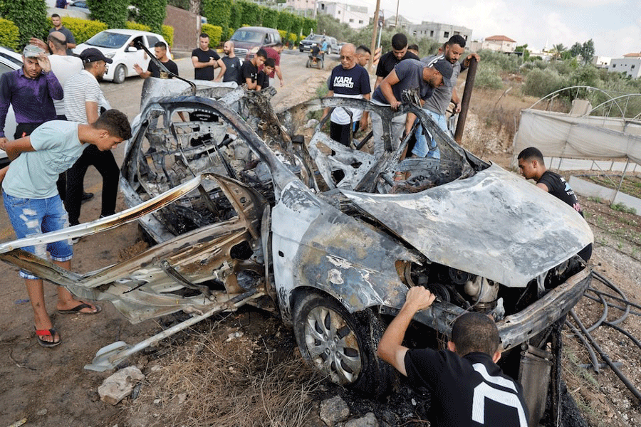 Palestinians inspect a vehicle damaged in an Israeli airstrike, in Zeita, near Tulkarm, in the Israeli-occupied West Bank, August 3, 2024.