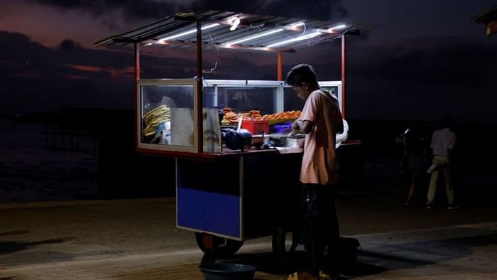 A vendor cooks food for customers in his food cart at Galle Face Green, amid the country's economic crisis, in Colombo, Sri Lanka, Oct 31, 2022. REUTERS