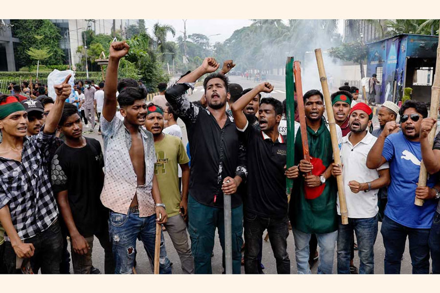 Demonstrators shout slogans after they have occupied a street during a protest demanding the stepping down of Bangladeshi Prime Minister Sheikh Hasina, following quota reform protests by students, in Dhaka, Bangladesh, August 4, 2024.