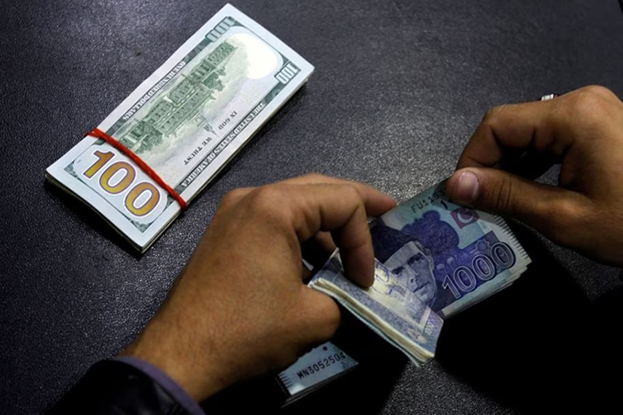 A currency trader counts Pakistani Rupee notes as he prepares an exchange of U.S dollars in Islamabad, Pakistan on December 11, 2017 — Reuters/Files