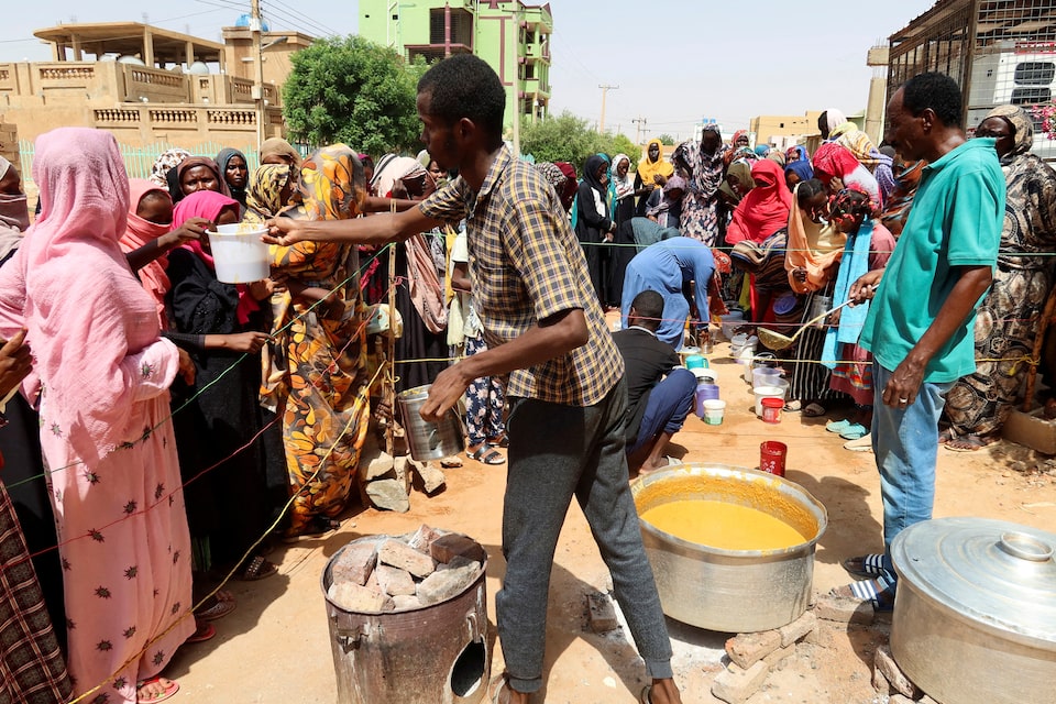A volunteer distributes food to people in Omdurman, Sudan, September 3, 2023. REUTERS/El Tayeb Siddig/File Photo