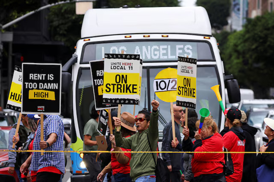 Hotel workers march and protest, while a bus driver waits to cross the road, as they continue their strike in Los Angeles, California, US on October 25, 2023 — Reuters/File
