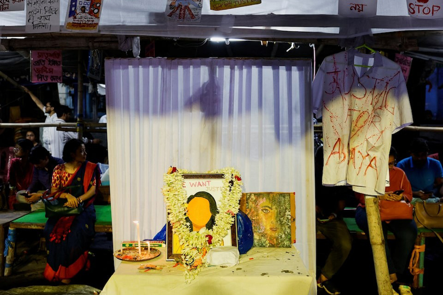 Medics sit behind an altar of framed images as they attend a protest condemning the rape and murder of a trainee medic, inside the premises of R G Kar Medical College and Hospital in Kolkata, India, August 20, 2024.
