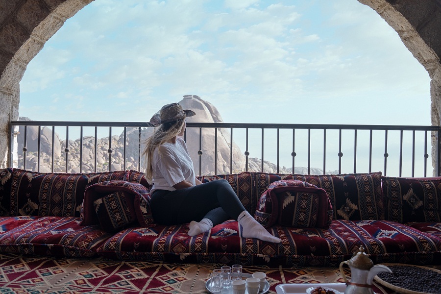 Woman enjoying the mountain view from a balcony