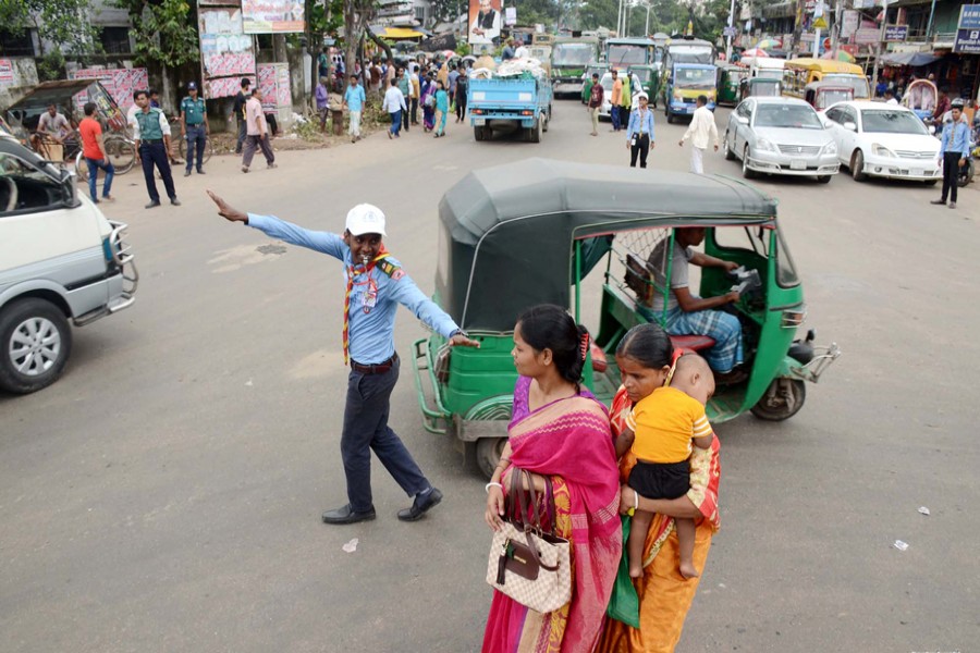 A member of Bangladesh Scouts assisting the traffic police in maintaining discipline on the road at the Oxygen intersection in Chattogram city on Wednesday — Focus Bangla