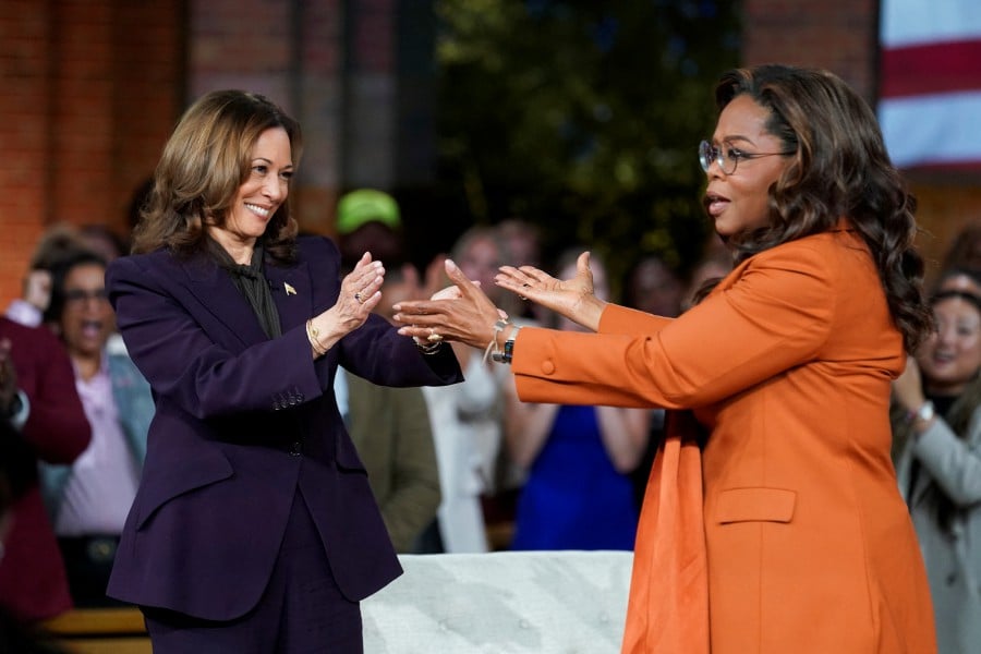 Democratic presidential nominee and US Vice President Kamala Harris and Oprah Winfrey react during a campaign event in Detroit, Michigan. - REUTERS PIC