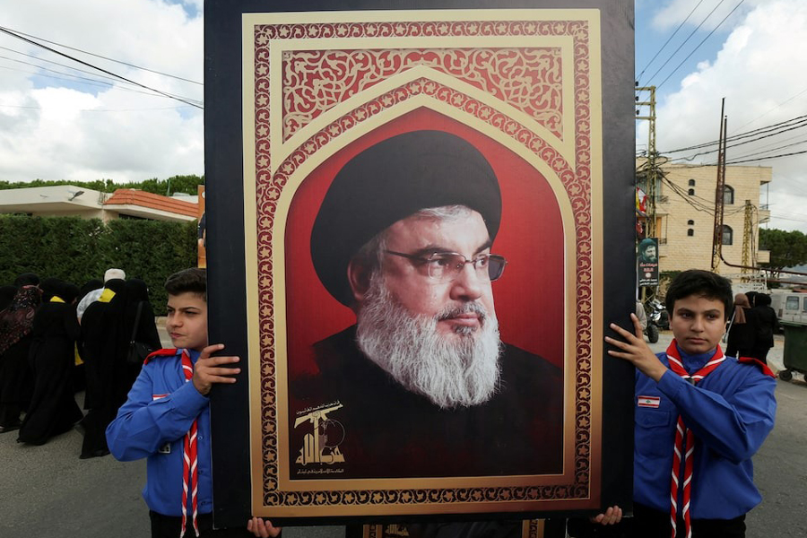 Boys scouts carry a picture of Hezbollah leader Sayyed Hassan Nasrallah during the funeral of Hezbollah member Ali Mohamed Chalbi, after hand-held radios and pagers used by Hezbollah detonated across Lebanon, in Kfar Melki, Lebanon September 19, 2024.