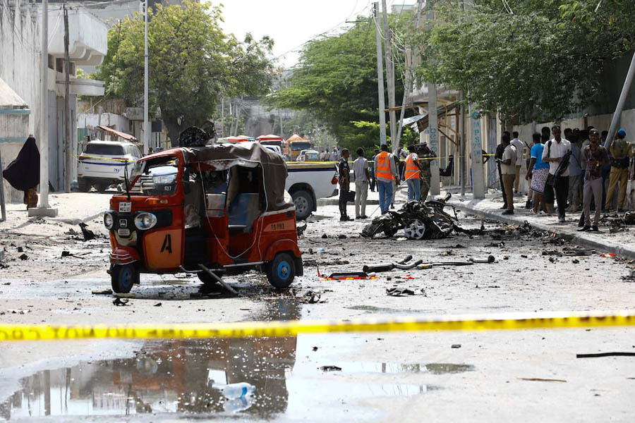 Somali security officers cordon off the area of the wreckage of a rickshaw at the scene of an explosion