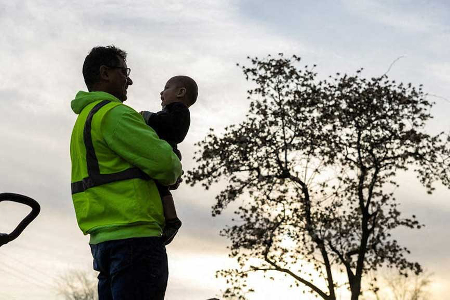 A man from Venezuela holds his son after returning home from a day of work at a construction site in Columbus, Ohio, US, Mar 25, 2024.