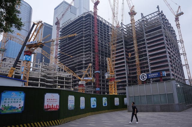 A person walks past a construction site in Beijing's Central Business District (CBD), China July 14, 2024. REUTERS/Tingshu Wang/File Photo