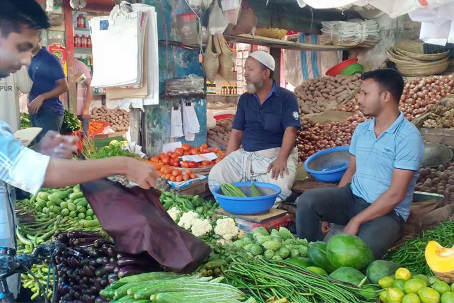 A customer buying vegetables from a shop at a kitchen market at Rangpur City Bazar