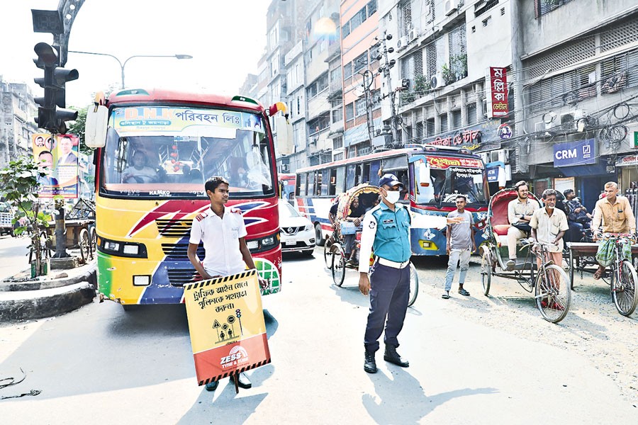 A student helping a traffic police to ensure discipline on the busy main road at Bangshal in Old Dhaka on Tuesday. The home adviser on Monday announced that 300 students would work alongside the police personnel in the capital from Oct 21 to Nov 4 to improve traffic management in the capital