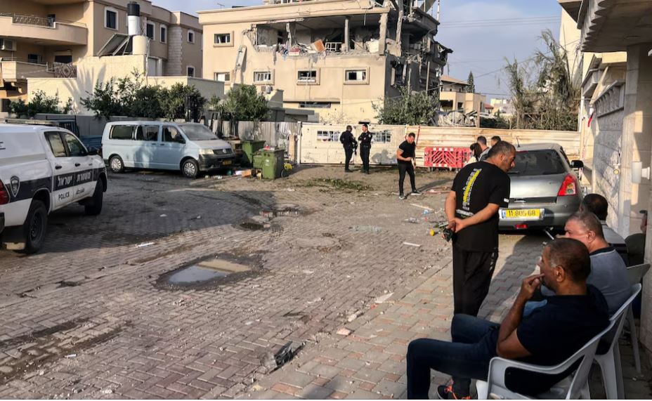 Residents and police officials gather near a house that was hit, following a projectiles attack from Lebanon towards Israel, amid cross-border hostilities between Hezbollah and Israel, in the central Israeli town of Tira, November 2, 2024. REUTERS/Rami Amichay