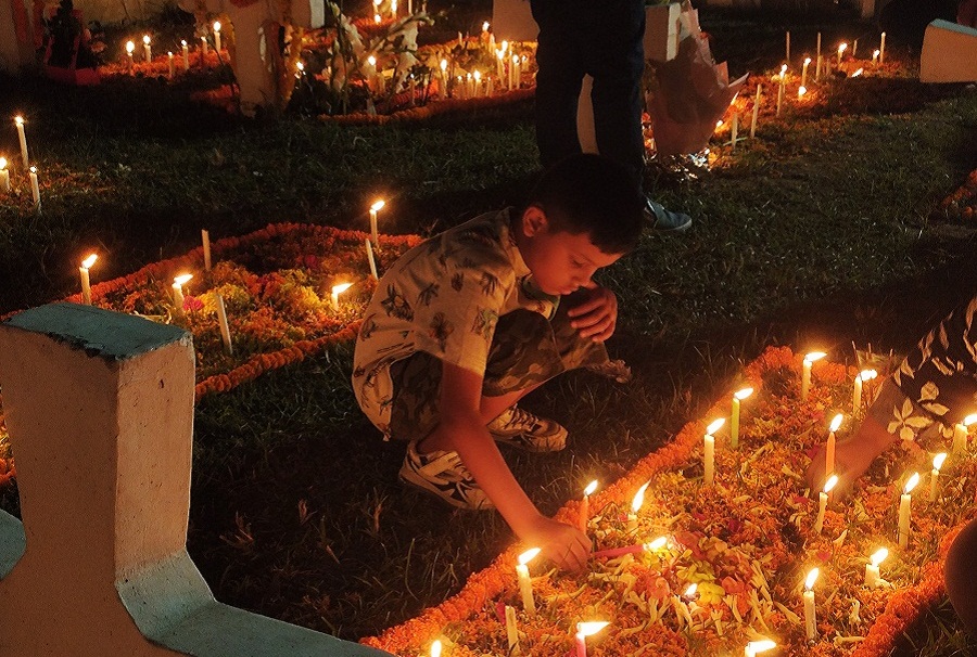 A kid is decorating a grave