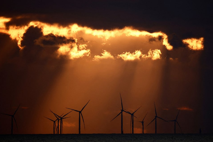 The sun sets behind wind turbines at the Saint-Nazaire offshore wind farm, off the coast of the Guerande peninsula in western France, February 25, 2023.