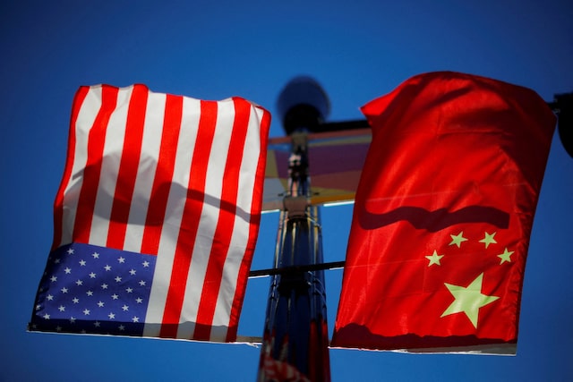 The flags of the United States and China fly from a lamppost in the Chinatown neighborhood of Boston, Massachusetts, U.S., November 1, 2021. REUTERS/Brian Snyder/File Photo