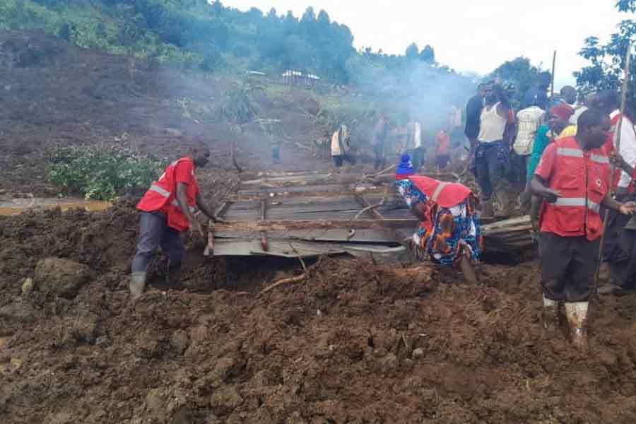Members of Uganda Red Cross Society (URCS) team work in collaboration with local authorities and community members after a landslide triggered by heavy rains, in Bulambuli District, Uganda, November 28, 2024.