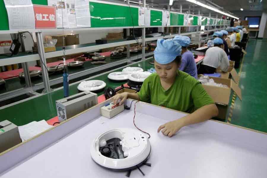 An employee works on the production line of a robot vacuum cleaner factory of Matsutek in Shenzhen, China August 9, 2019.