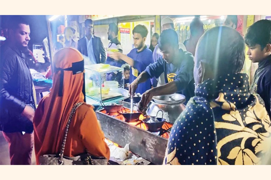 Photo shows two youths making 'chitoi and vapa' cakes and customers waiting at Stadium Road in the town