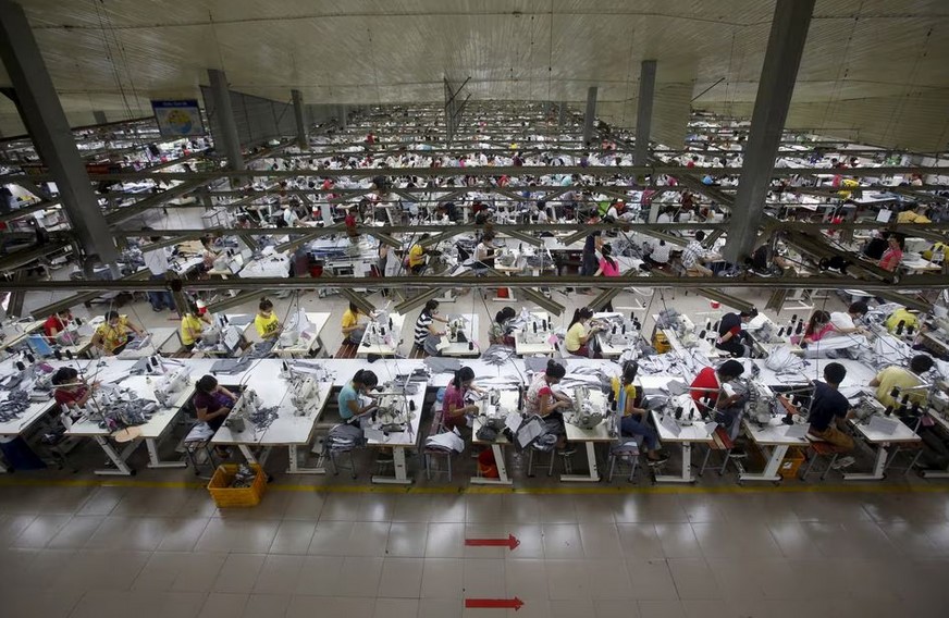 Labourers work at a garment factory in Bac Giang province, near Hanoi October 21, 2015. Vietnam's textiles and footwear would gain strongly from the TPP, after exports of $31 billion last year for brands such as Nike, Adidas, H&M, Gap, Zara, Armani and Lacoste. REUTERS/Kham