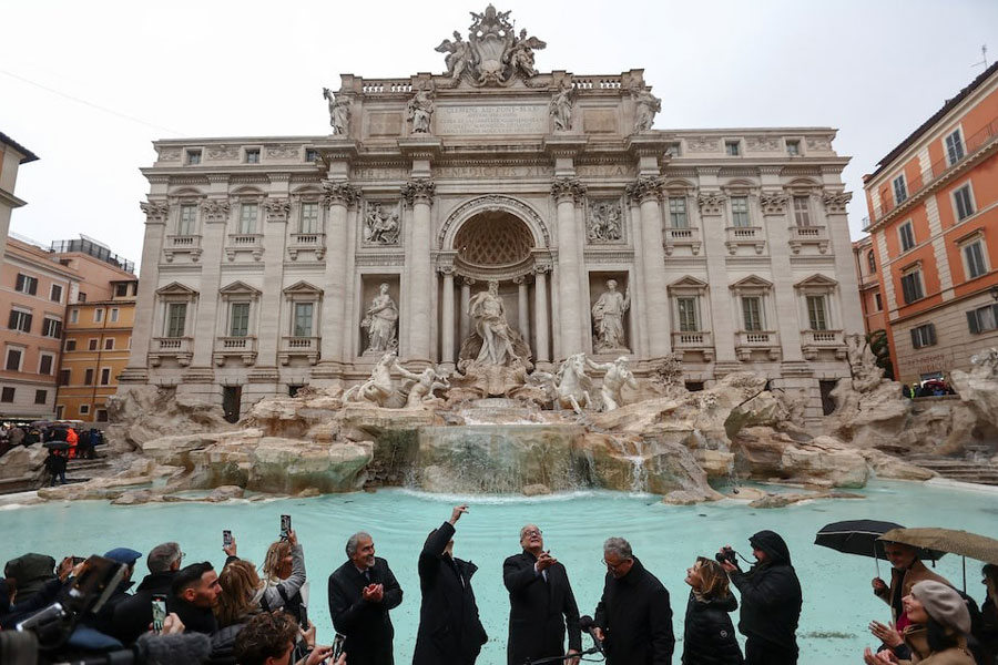 Rome’s Mayor Roberto Gualtieri tosses a coin into the Trevi Fountain as it reopens to the public after maintenance work, in Rome, Italy, December 22, 2024.