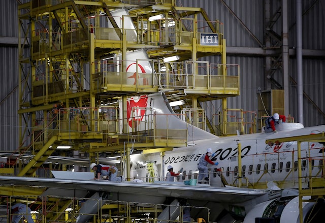 Maintenance workers are seen atop of an airplane of Japan Airlines (JAL) at a hangar of Haneda airport in Tokyo, Japan, April 2, 2018. REUTERS/Issei Kato/File Photo