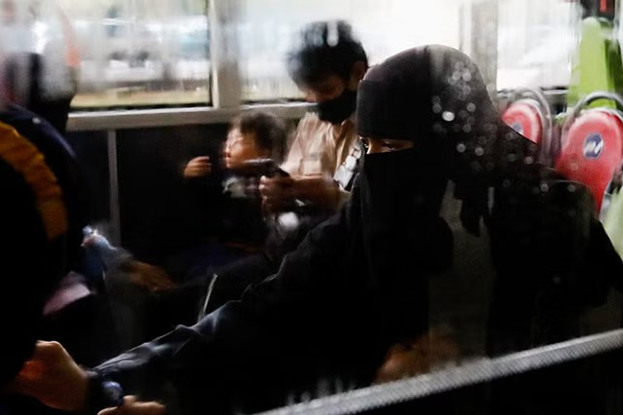 An Indonesian citizen evacuated from Sudan sits in a bus after she arrives at the Soekarno-Hatta Airport in Tangerang, on the outskirts of Jakarta, Indonesia, April 28, 2023.