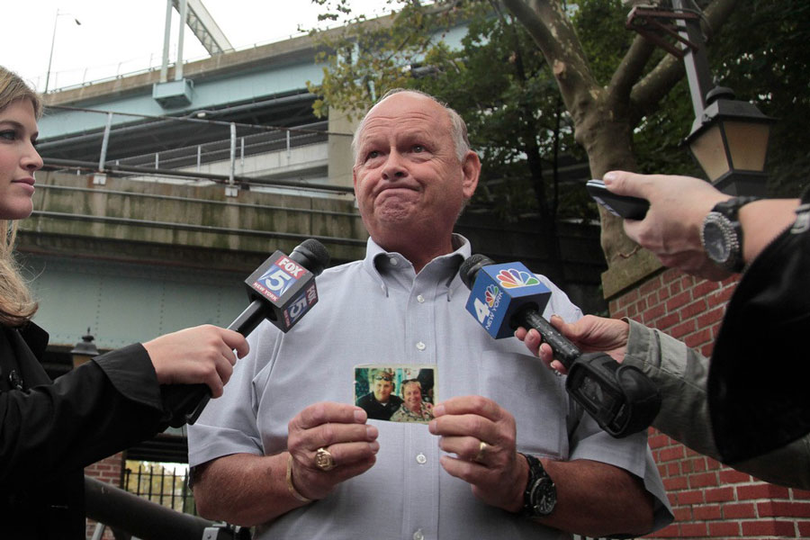 Ken Fairben holds a photo showing his son Keith, left, a victim of the Sept, 11, attacks, as he talks with reporters Oct 15, 2012, outside Fort Hamilton Army base in Brooklyn, NY. AP/Bebeto Matthews/Files