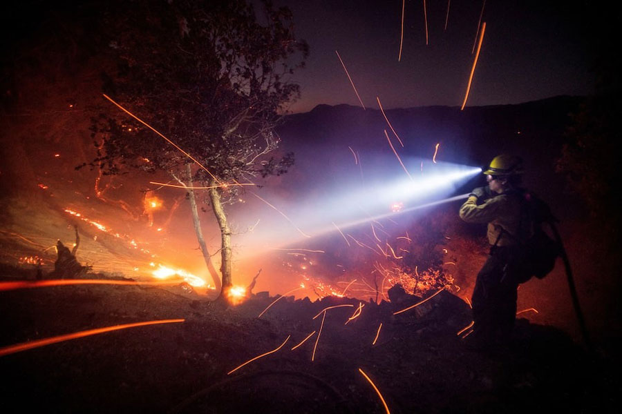 The wind whips embers while a firefighter battles the fire in the Angeles National Forest near Mt. Wilson as the wildfires burn in the Los Angeles area, during the Eaton Fire in Altadena, California, US, January 9, 2025.