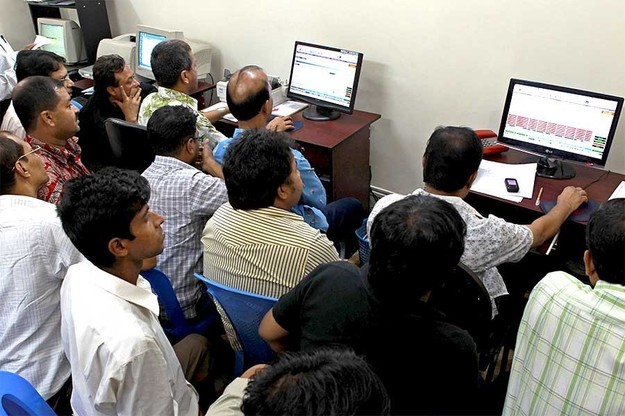 Investors monitoring stock price movements on computer screens at a brokerage house in the capital city — FE/file